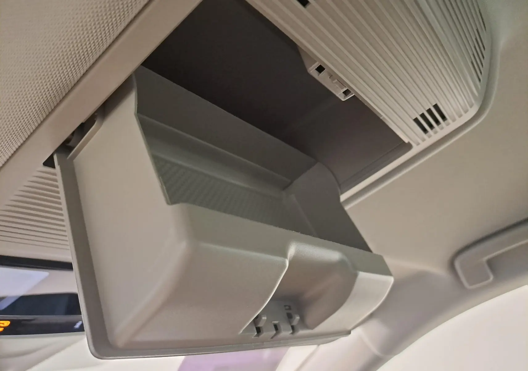 Rangement lunettes ouvert dans le plafond intérieur du Skoda Octavia Combi blanc Moon, vue en plongée depuis l'avant.