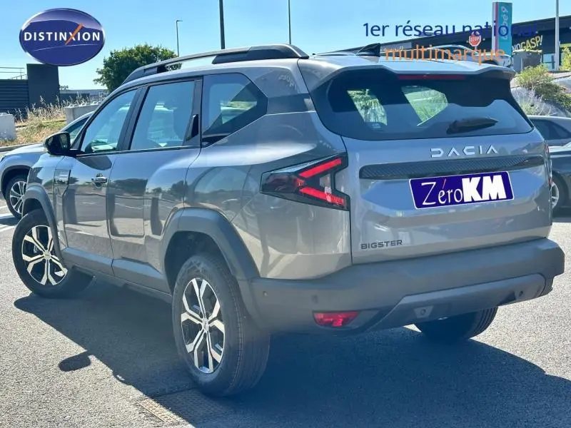 Vue 3/4 arrière droite du Dacia Bigster gris avec jantes alu et feux arrière LED distinctifs.