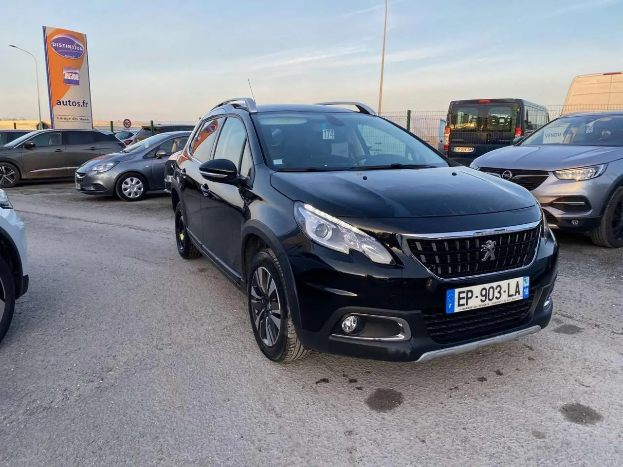 Peugeot 2008 noir Perla Nera en 3/4 avant droit, avec jantes aluminium diamantées et feux diurnes LED visibles.