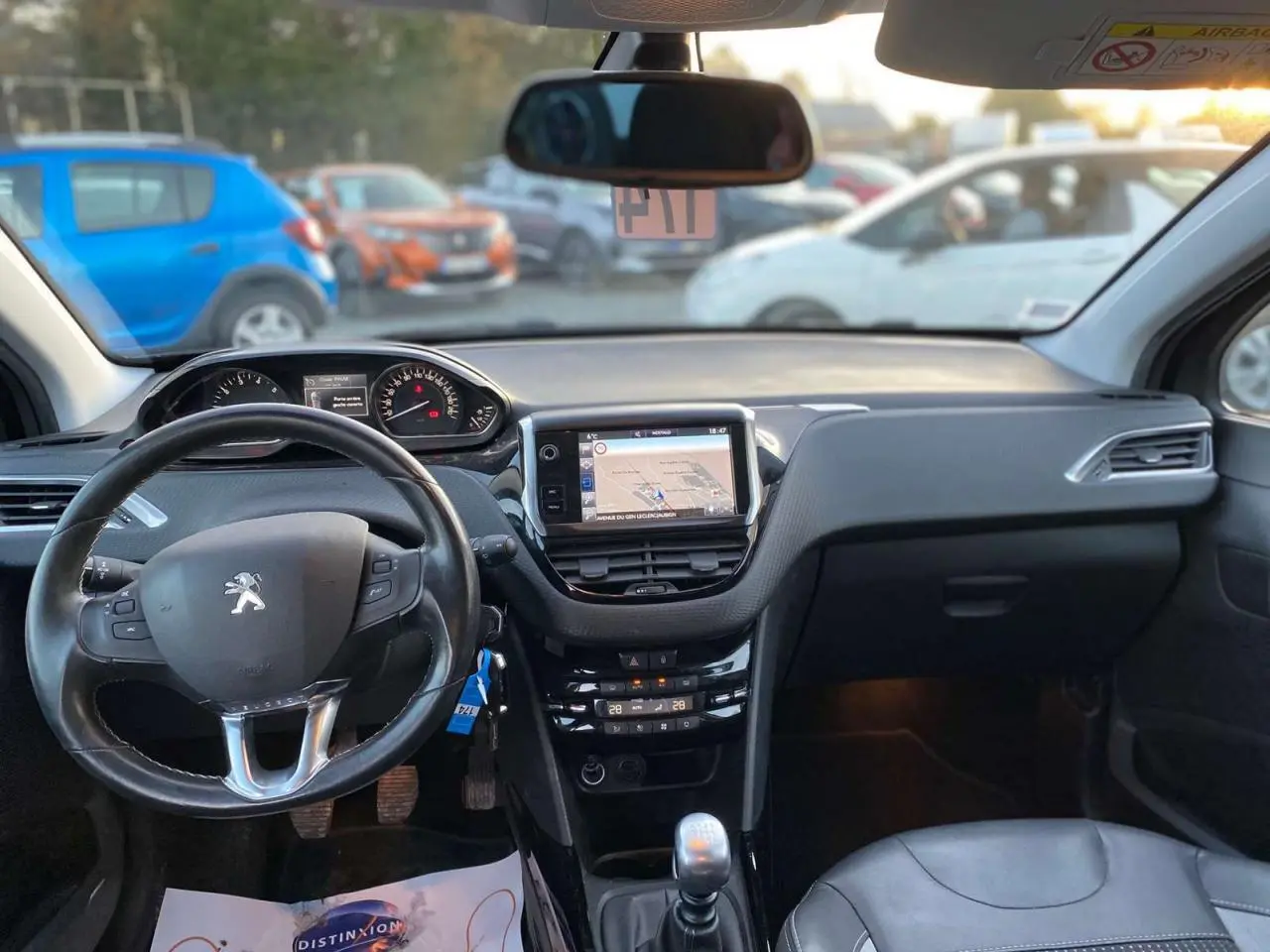 Intérieur de Peugeot 2008 noir Perla Nera 2017, vue frontale sur tableau de bord avec écran tactile et levier manuel.