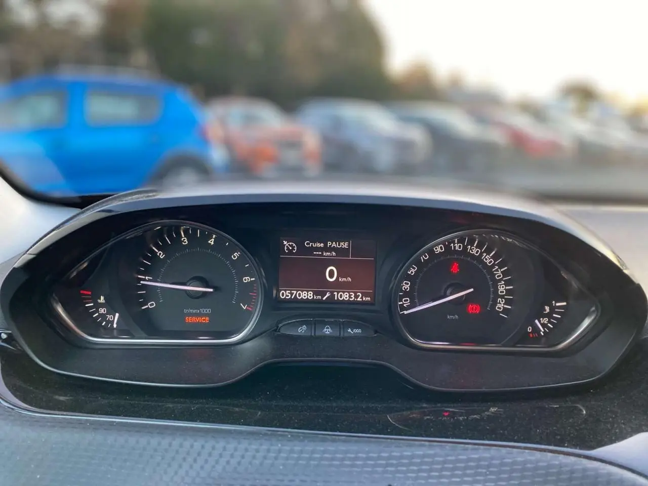 Vue rapprochée du tableau de bord du Peugeot 2008 noir Perla Nera, affichant 57 088 km et régulateur en pause.