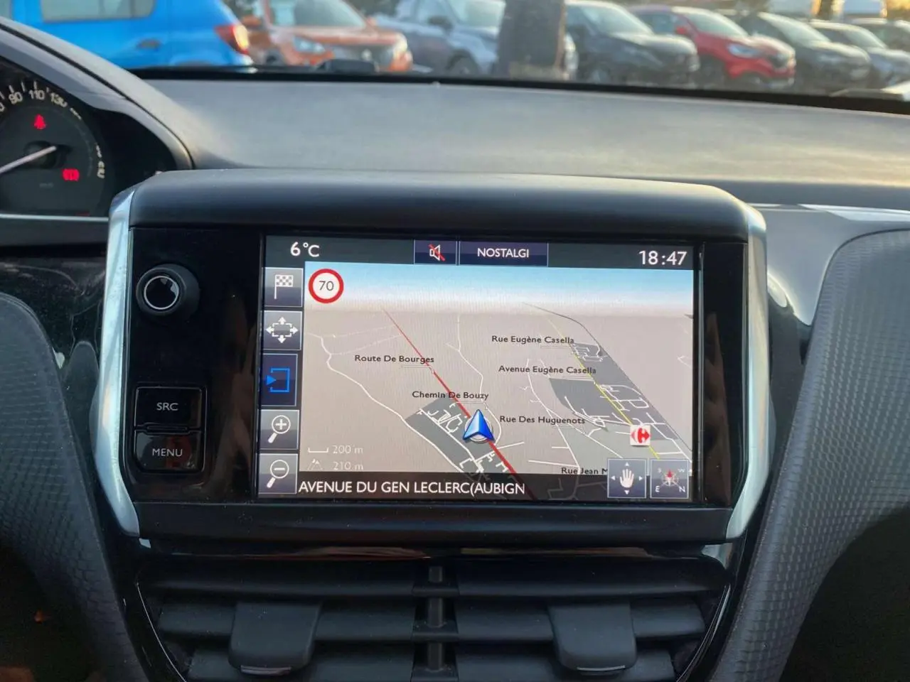 Écran tactile central du tableau de bord d'une Peugeot 2008 noire, affichant la navigation GPS en extérieur.