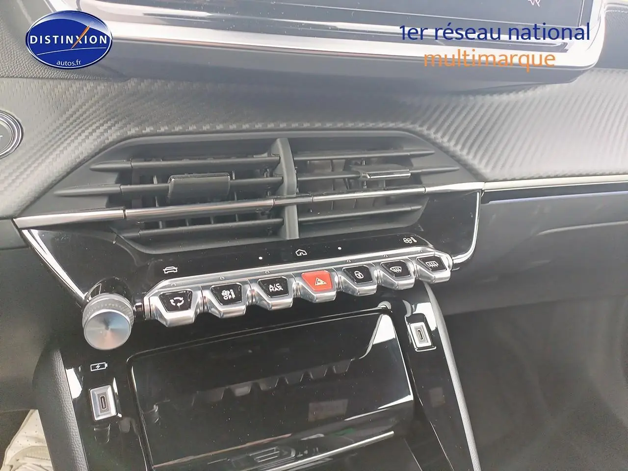 Vue rapprochée du tableau de bord noir brillant du Peugeot 2008 1.2 hybrid 145 GT e-DCS6 avec commandes tactiles et aérateurs.