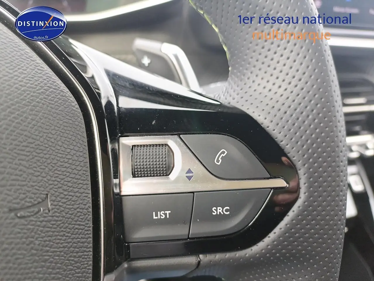 Gros plan sur les commandes gauche du volant cuir perforé du Peugeot 2008 1.2 hybrid 145 GT e-EAT8.