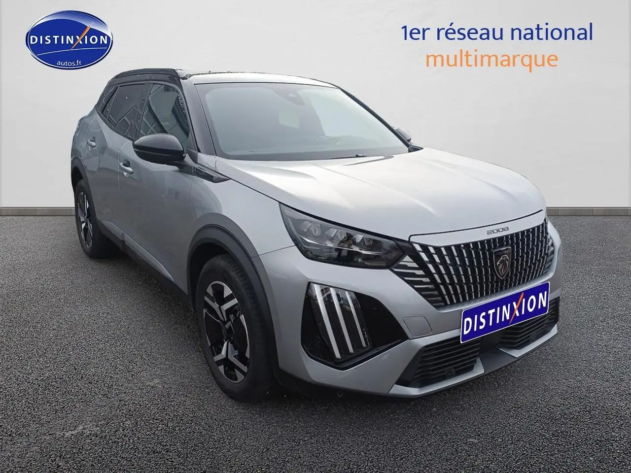 Peugeot 2008 hybride 2025 gris Artense en 3/4 avant, avec calandre distinctive et jantes alu noires.