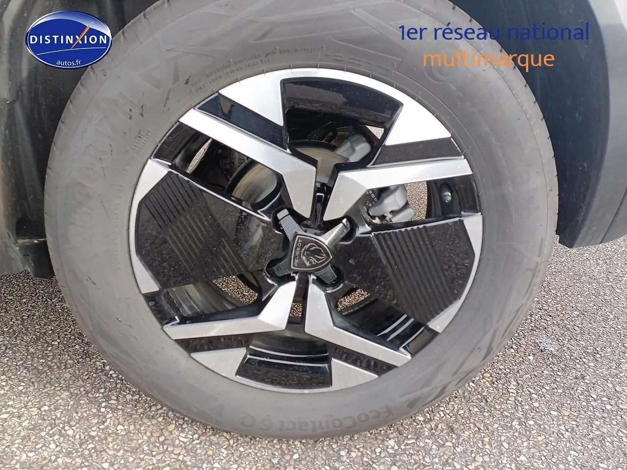 Gros plan sur la jante alu bicolore noire et argentée d'un Peugeot 2008 1.2 hybrid 145 GT e-EAT8 gris Artense.