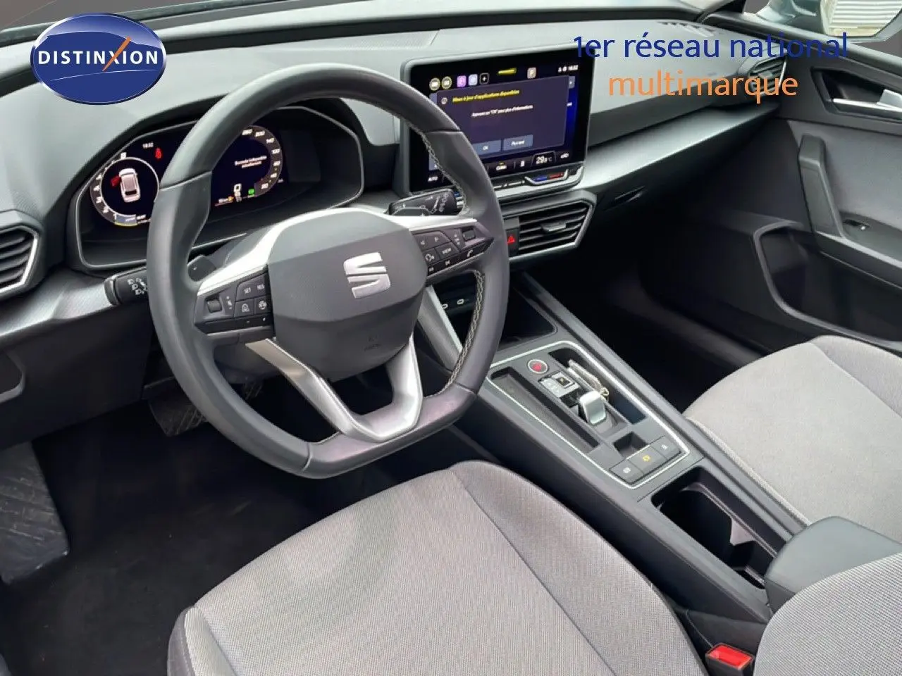 Intérieur de la SEAT LEON 2025 en gris Fiord, vue côté conducteur sur le tableau de bord et la console centrale moderne.