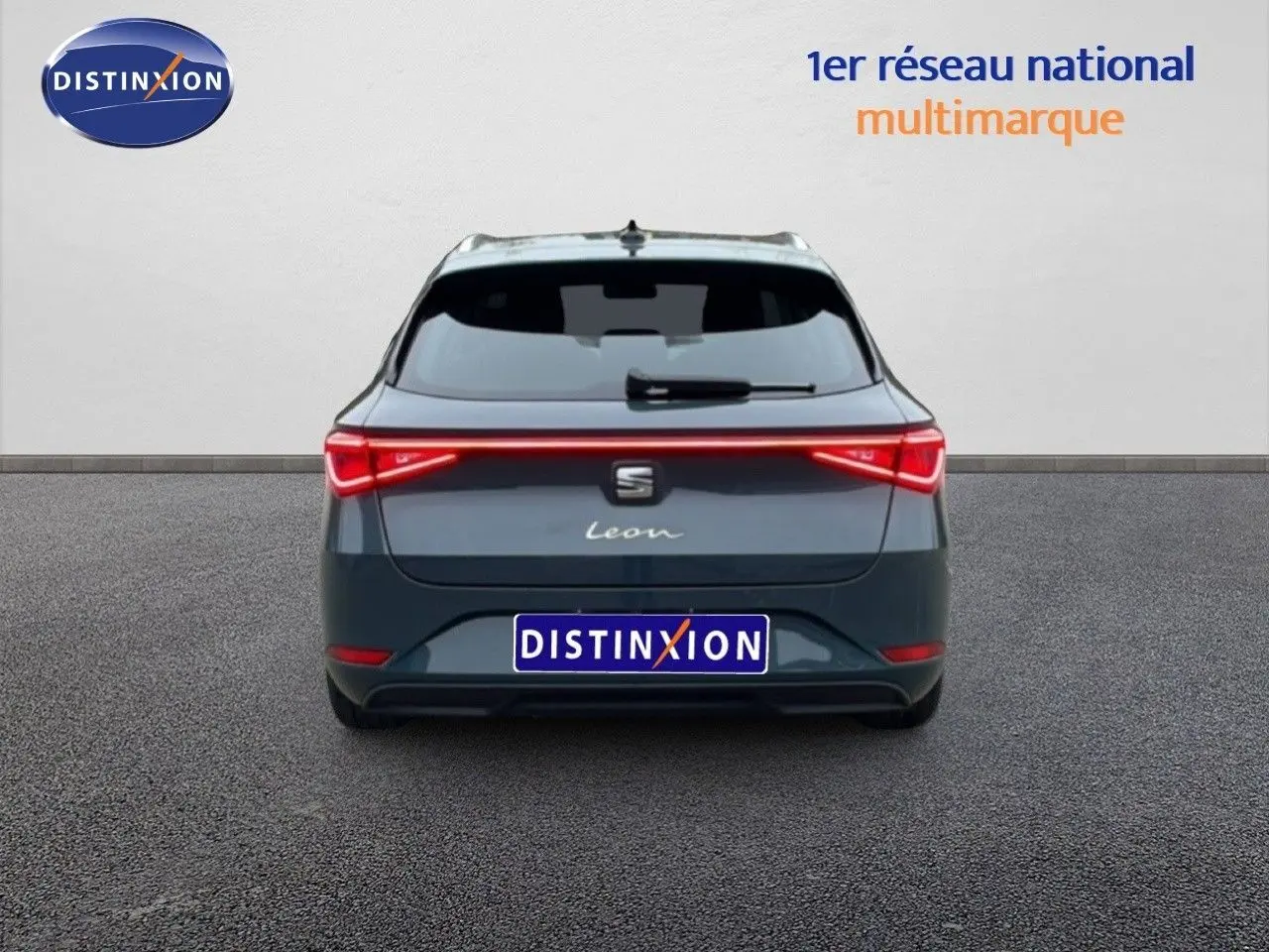 Vue arrière d'une SEAT Leon IV gris Fiord avec feux LED reliés, immatriculée Distinxion, sur fond neutre.
