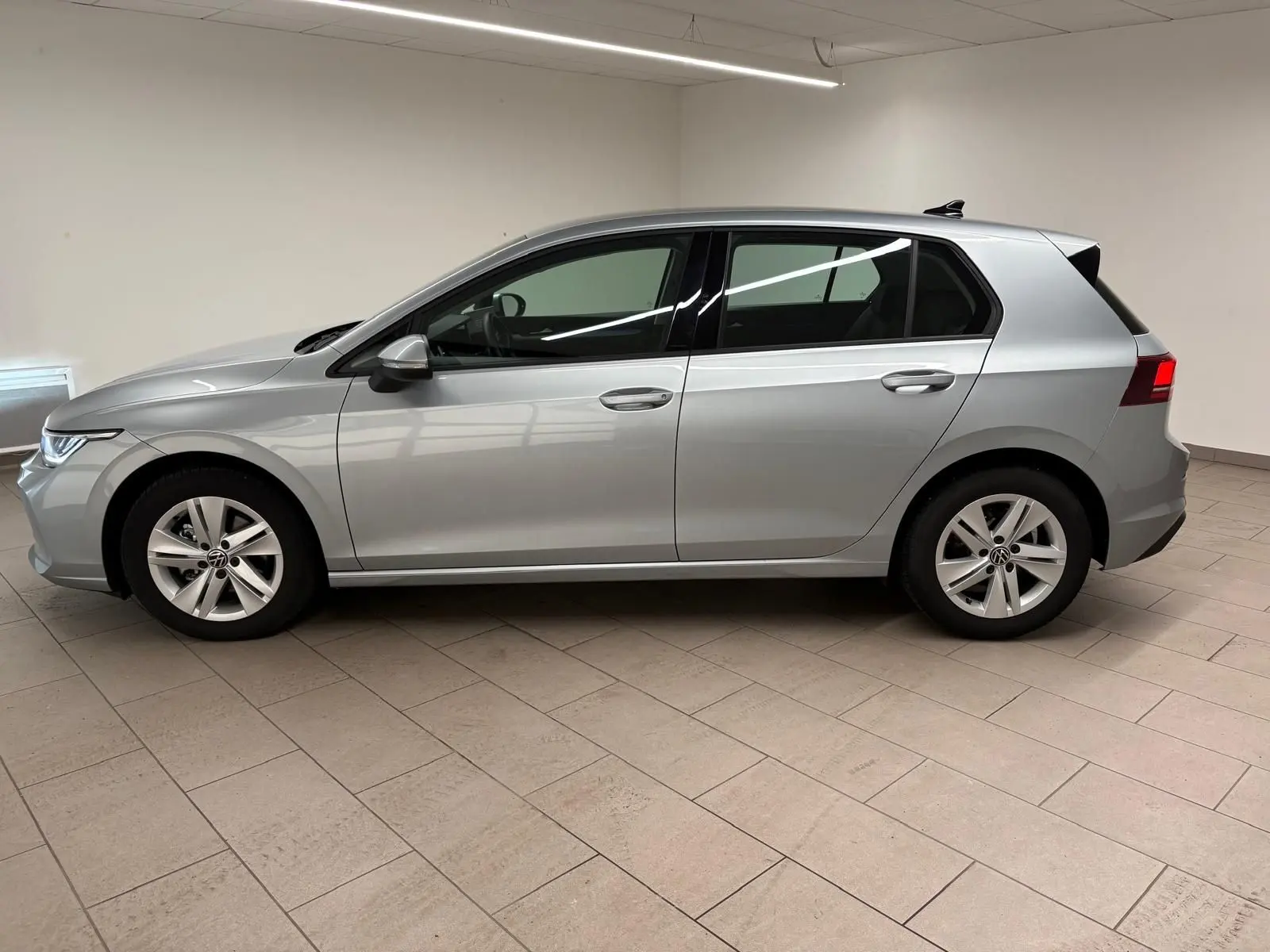 Vue de profil côté gauche d'une Volkswagen Golf 2.0 TDI 116 BVM6 Life Plus 2025 en couleur reflet d'argent.