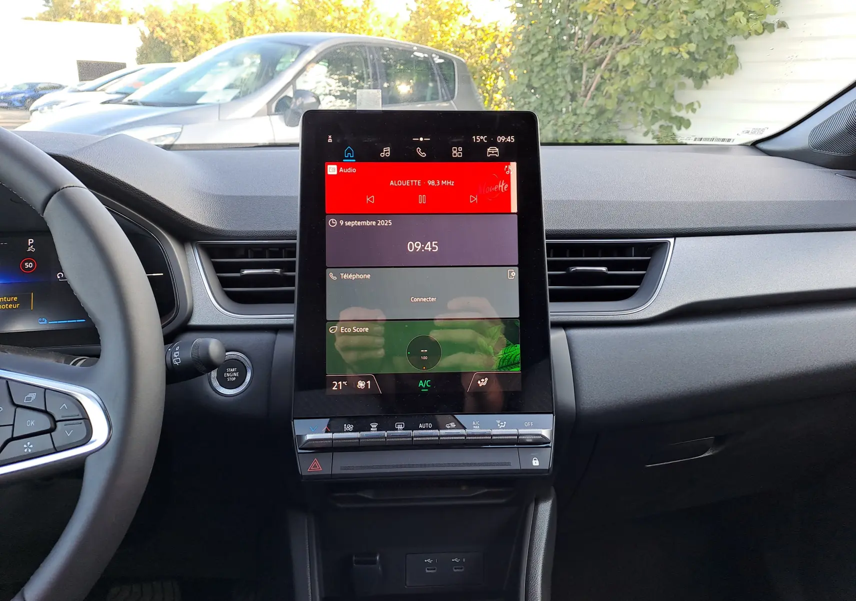 Plan rapproché de l'écran tactile central du tableau de bord du Renault Captur blanc nacré avec toit gris Highland, intérieur gris.