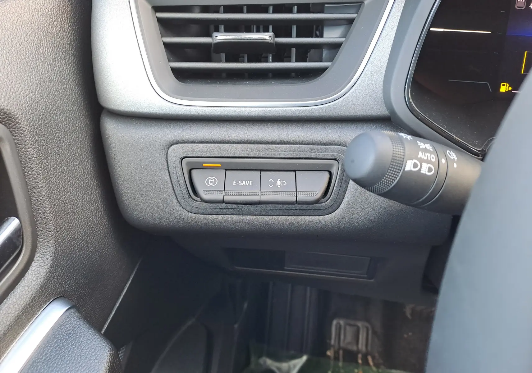 Gros plan sur les commandes E-SAVE et réglage des phares à gauche du volant du Renault Captur blanc nacré 2025.