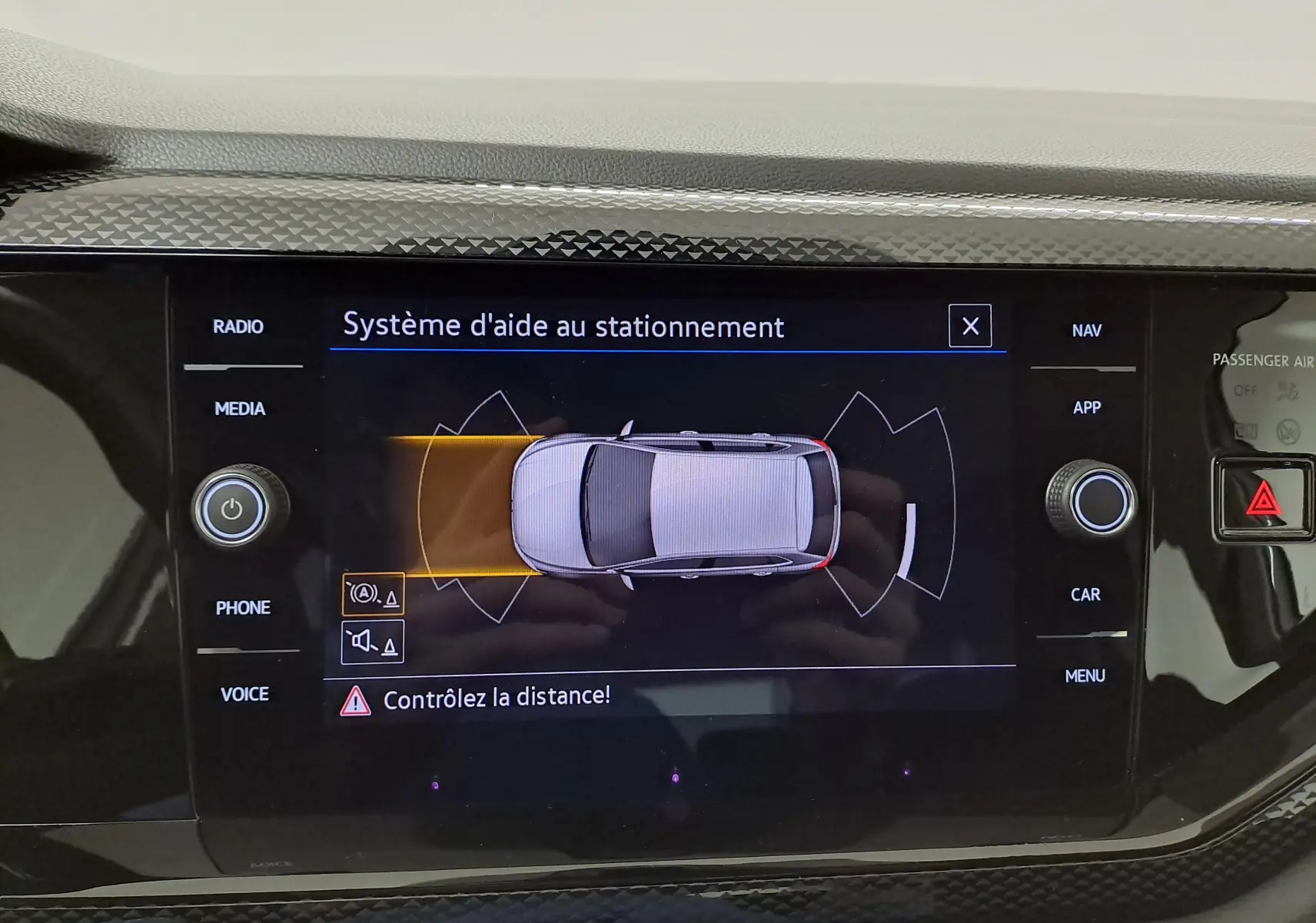 Écran central du système d'aide au stationnement de la Volkswagen Polo 2024 montrant une vue aérienne du véhicule blanc pur.