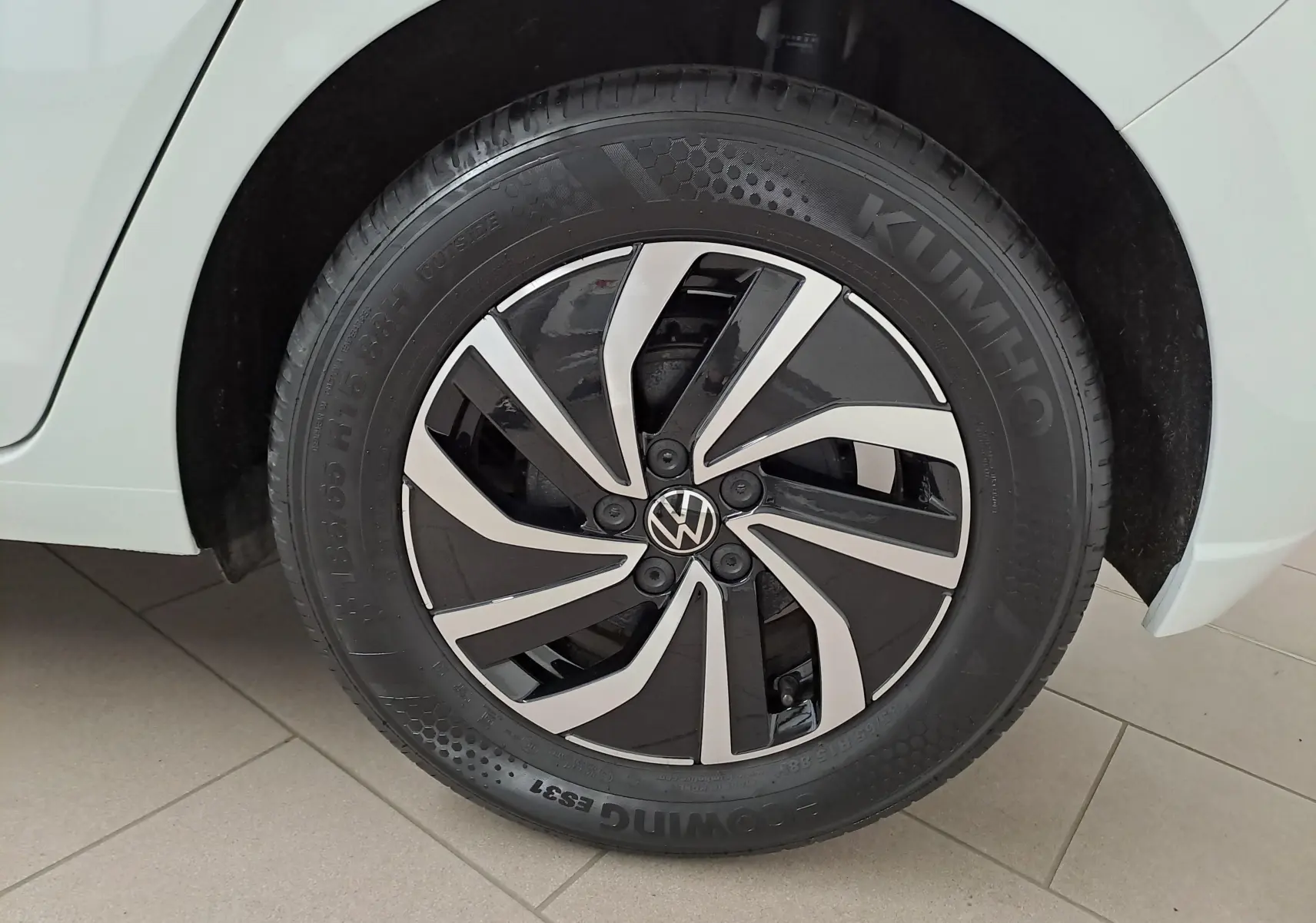 Gros plan sur la roue avant droite de la Volkswagen Polo blanc pur 2024 avec jante alliage noire et argentée distinctive.