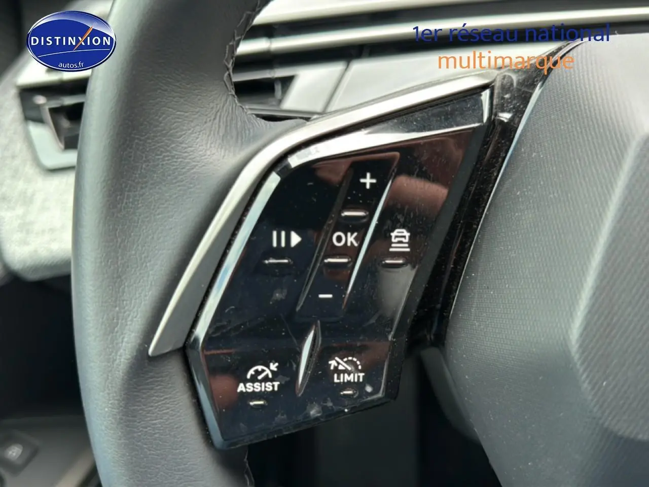 Gros plan sur les commandes multifonctions à gauche du volant cuir du Peugeot 3008 gris titane 2025.