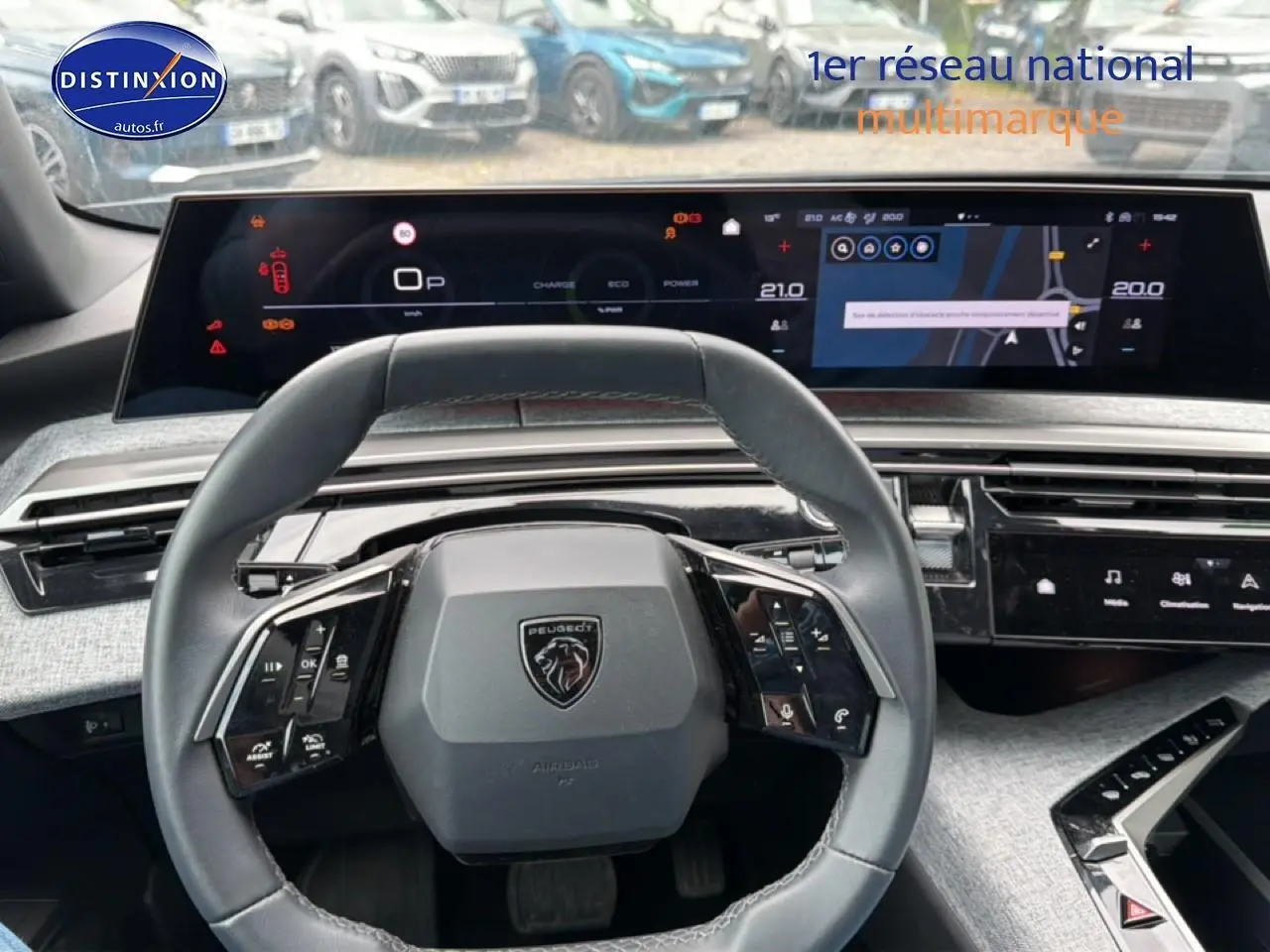 Vue intérieure centrée sur le volant cuir multifonction et l'écran tactile du Peugeot 3008 gris titane 2025.