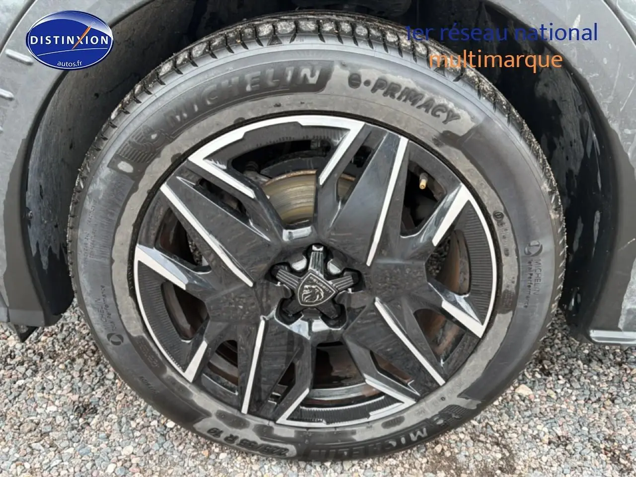 Gros plan sur la jante alu noire et argentée du Peugeot 3008 gris titane, avec pneu Michelin visible.