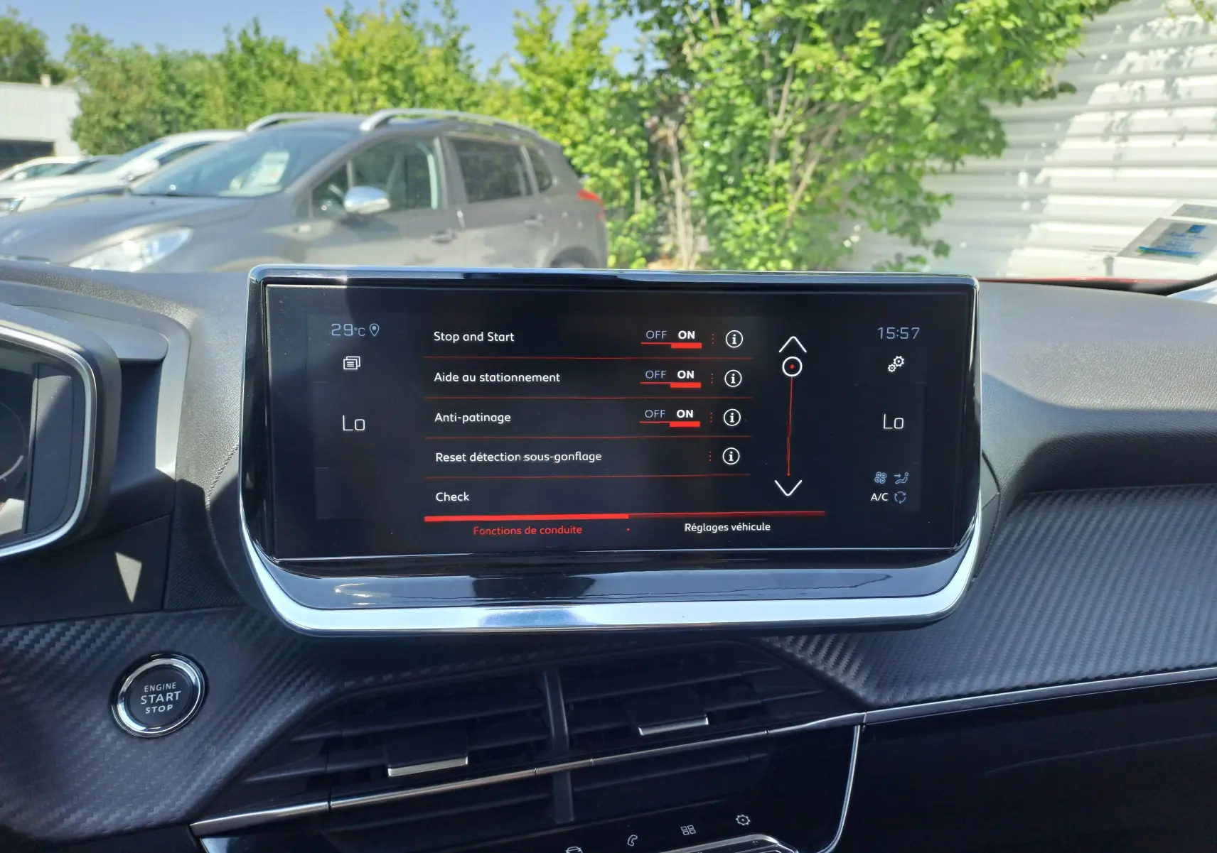 Écran tactile central du Peugeot 2008 rouge 2021 affichant les réglages d'aide à la conduite, vue intérieure avant.