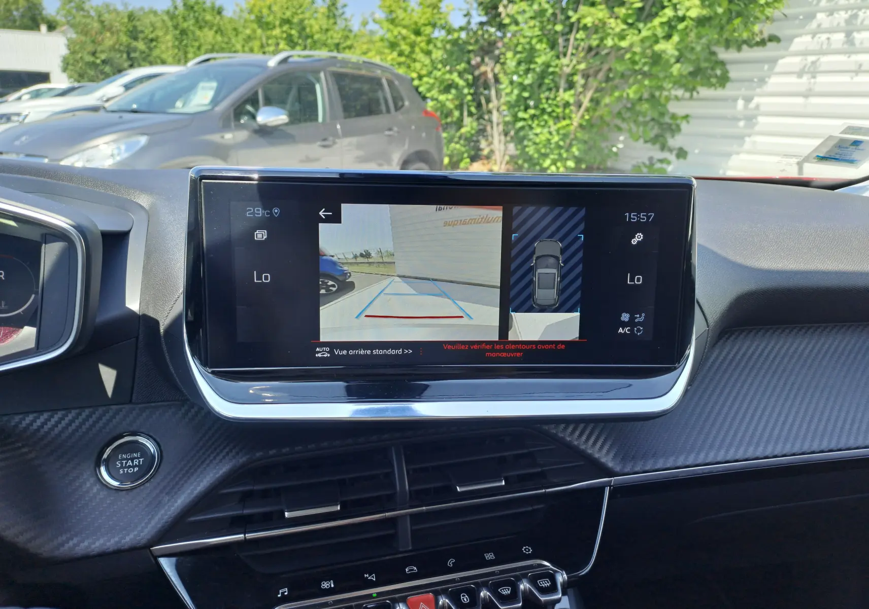 Vue intérieure du tableau de bord du Peugeot 2008 rouge 2021, écran affichant caméra de recul et commandes modernes.