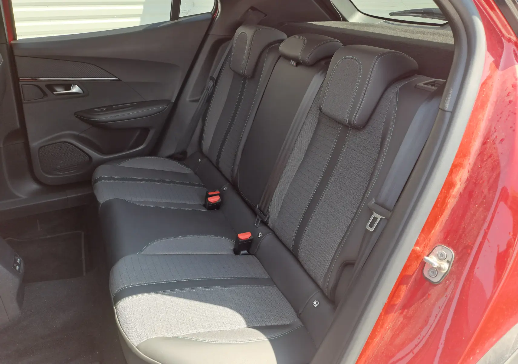Vue intérieure arrière droite des sièges arrière noirs et gris du Peugeot 2008 rouge de 2021, version BlueHDi 130 Allure Business.