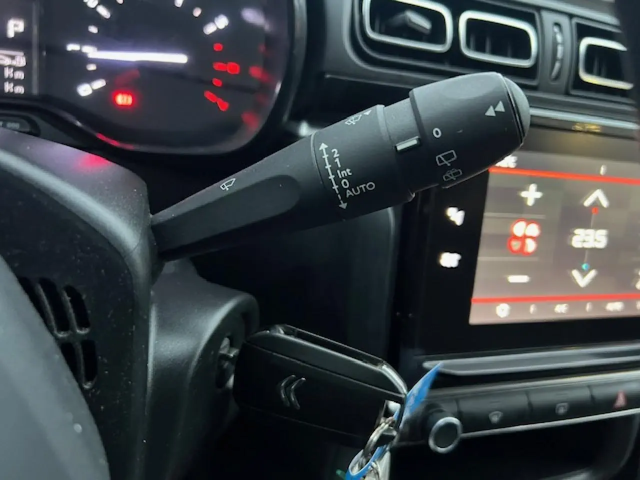 Gros plan sur la commande d’essuie-glace et le tableau de bord numérique d’une Citroën C3 Shine 2023.