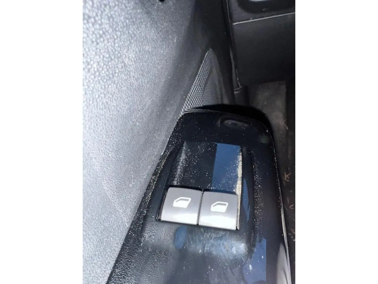 Gros plan sur les commandes de lève-vitres côté conducteur d'une Citroën C3 Shine 2023 noir toit rouge.