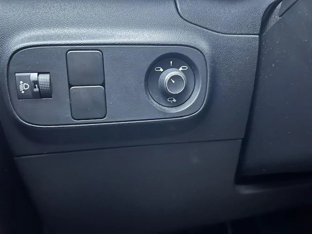 Gros plan sur les commandes de réglage des rétroviseurs côté conducteur d'une Citroën C3 Shine 2023 noir toit rouge.