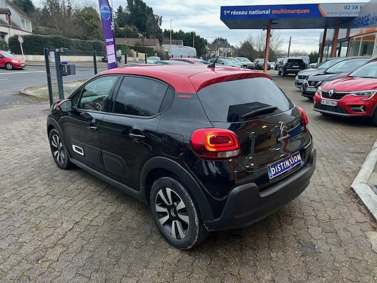 Citroën C3 Shine 2023 vue 3/4 arrière côté gauche, noir avec toit rouge et jantes alliage diamantées.