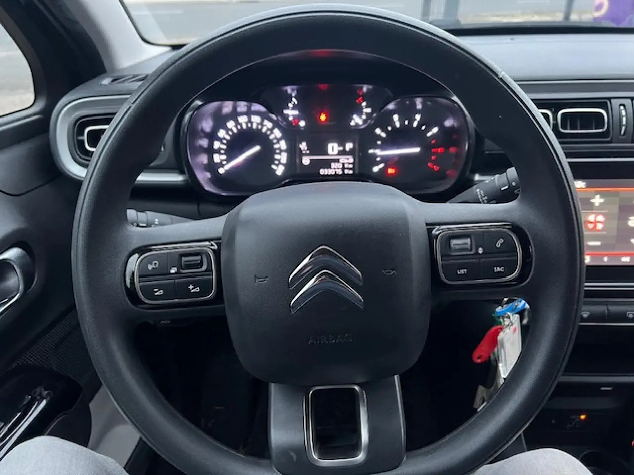 Vue centrée sur le volant noir de la Citroën C3 Shine 2023, avec tableau de bord et commandes au volant visibles.