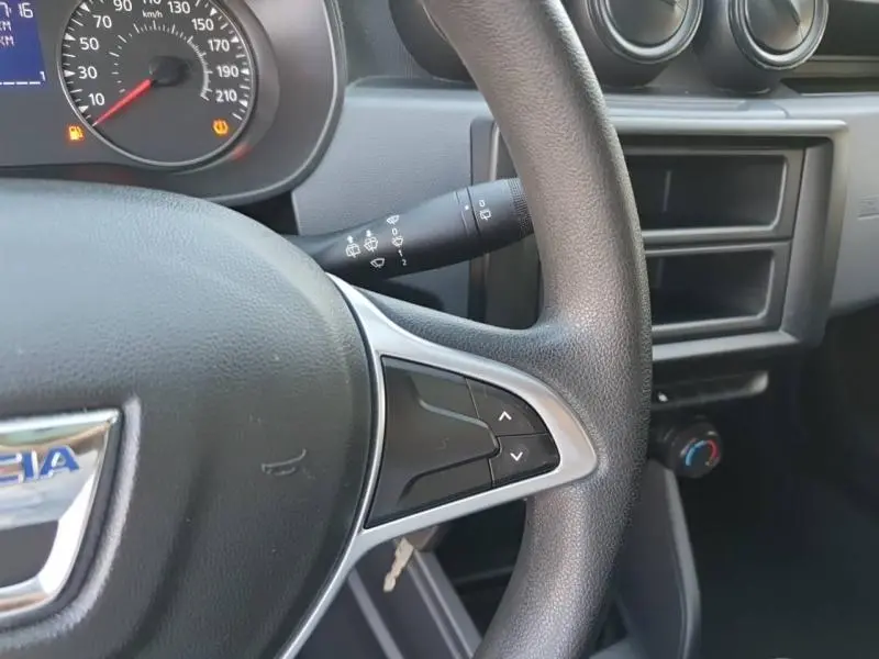 Gros plan sur le volant noir du Dacia Duster 2021 montrant les commandes intégrées et le tableau de bord partiel.