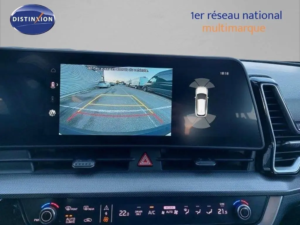 Écran central du Kia Sportage 2024 montrant la caméra de recul et les capteurs d’aide au stationnement.