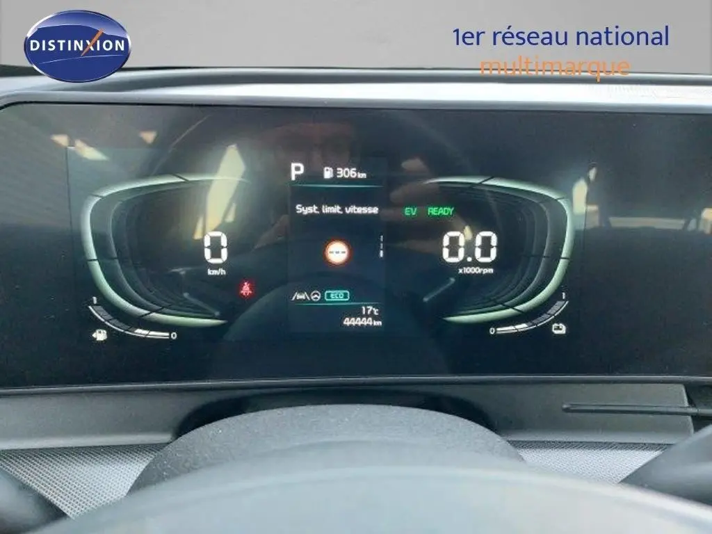 Tableau de bord numérique du Kia Sportage hybride 2024 affichant vitesse, régime et autonomie, vu de face depuis le poste de conduite.