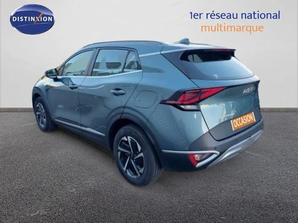 Vue 3/4 arrière droite d'un Kia Sportage gris Sirius Metal 2024 avec feux LED et jantes bi-ton.