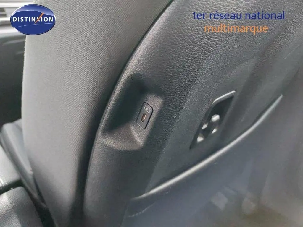 Détail du port USB intégré au dossier du siège arrière d'un Kia Sportage gris Sirius Metal 2024.