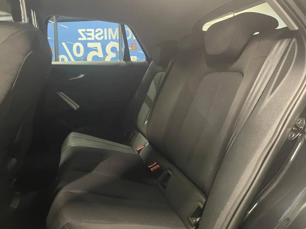 Vue intérieure côté droit des sièges arrière noirs du SUV Audi Q2 2023 finition S line.