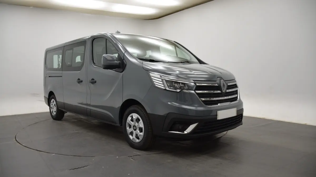 Renault Trafic Fourgon gris clair vu en 3/4 avant droit, avec calandre chromée et feux LED distinctifs.