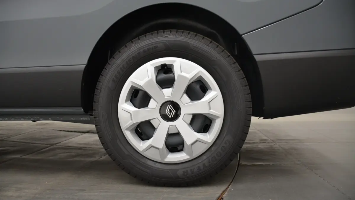 Gros plan sur la roue arrière droite d’un Renault Trafic Fourgon gris clair, avec jante en plastique et pneu Goodyear.