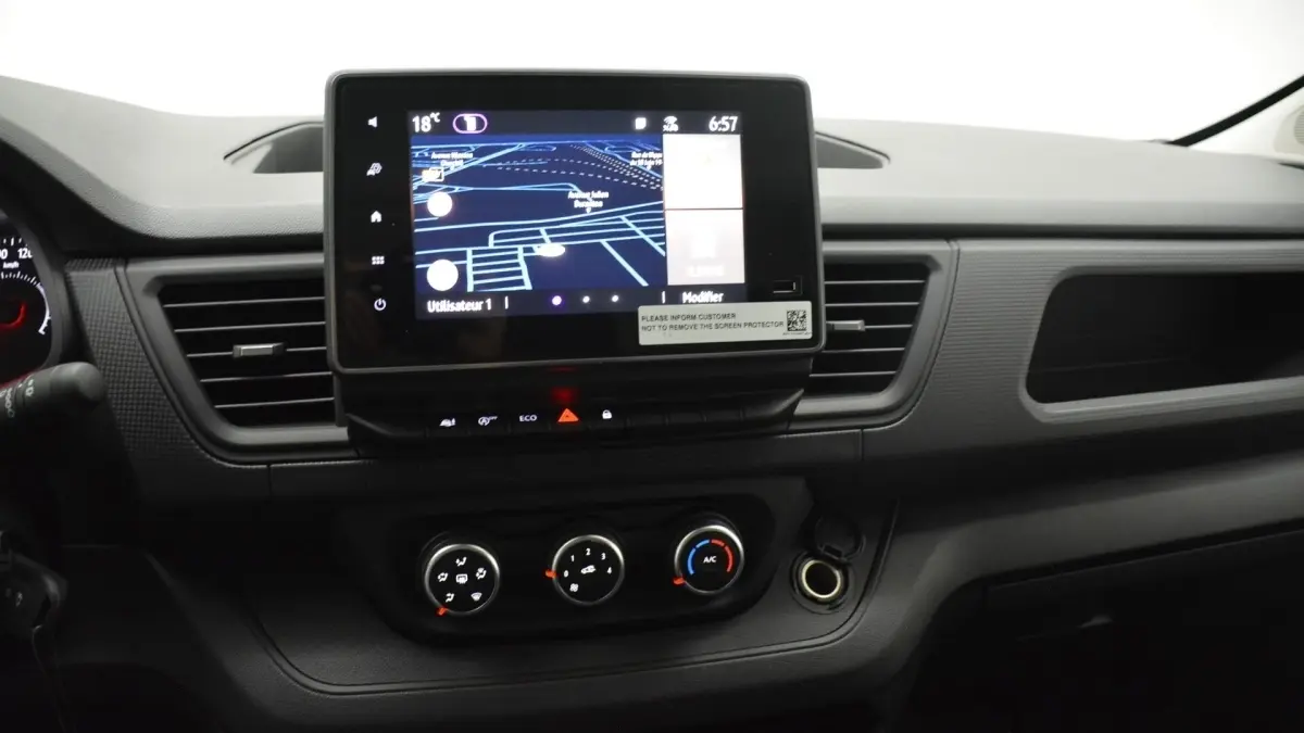 Vue intérieure du tableau de bord du Renault Trafic Fourgon 2025 avec écran tactile central et commandes de climatisation.