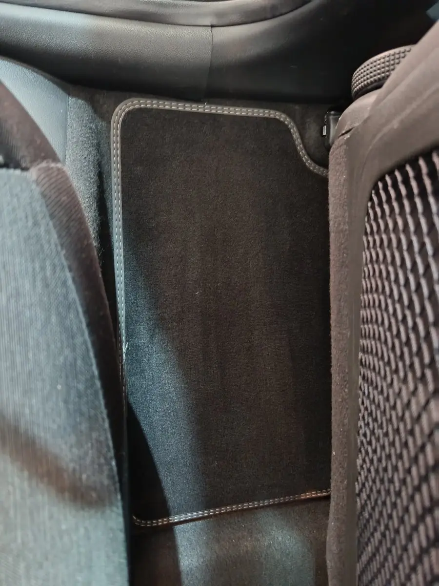 Vue rapprochée du tapis de sol noir entre les sièges arrière d'un Hyundai Kona électrique bleu 2022.