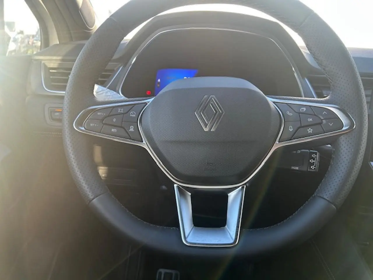 Vue rapprochée du volant noir perforé avec logo Renault au centre du Renault Symbioz 2025.