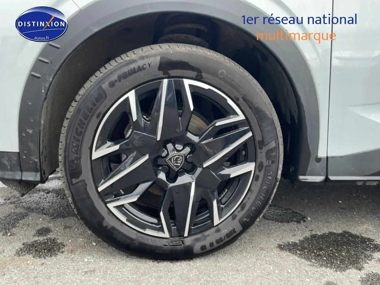 Gros plan sur la jante alu noire et argentée du côté avant droit d’un Peugeot 3008 blanc.