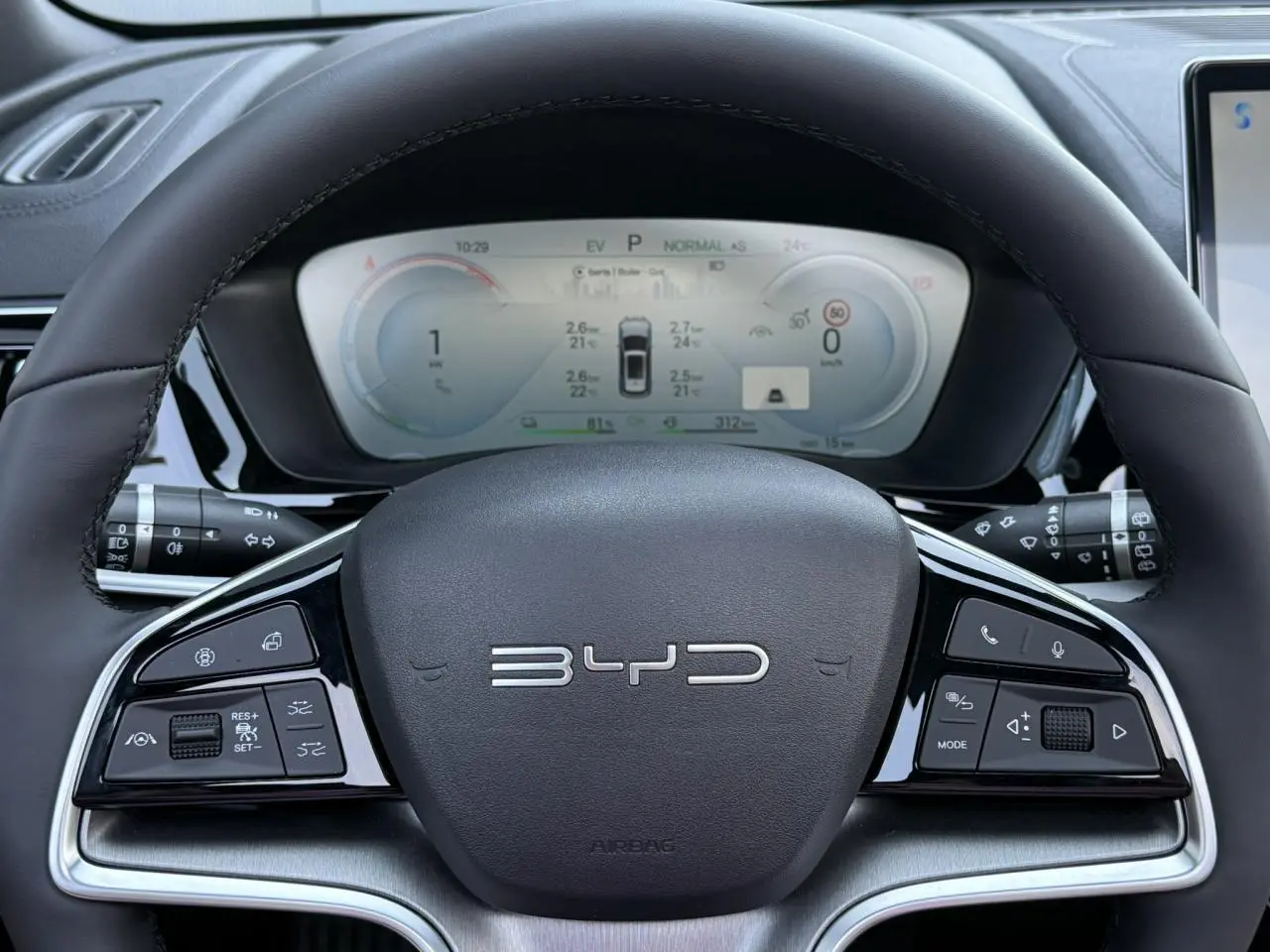 Vue rapprochée du volant noir de la BYD SEAL U 1.5 DM-i 218 Boost avec commandes multifonctions et tableau de bord digital.
