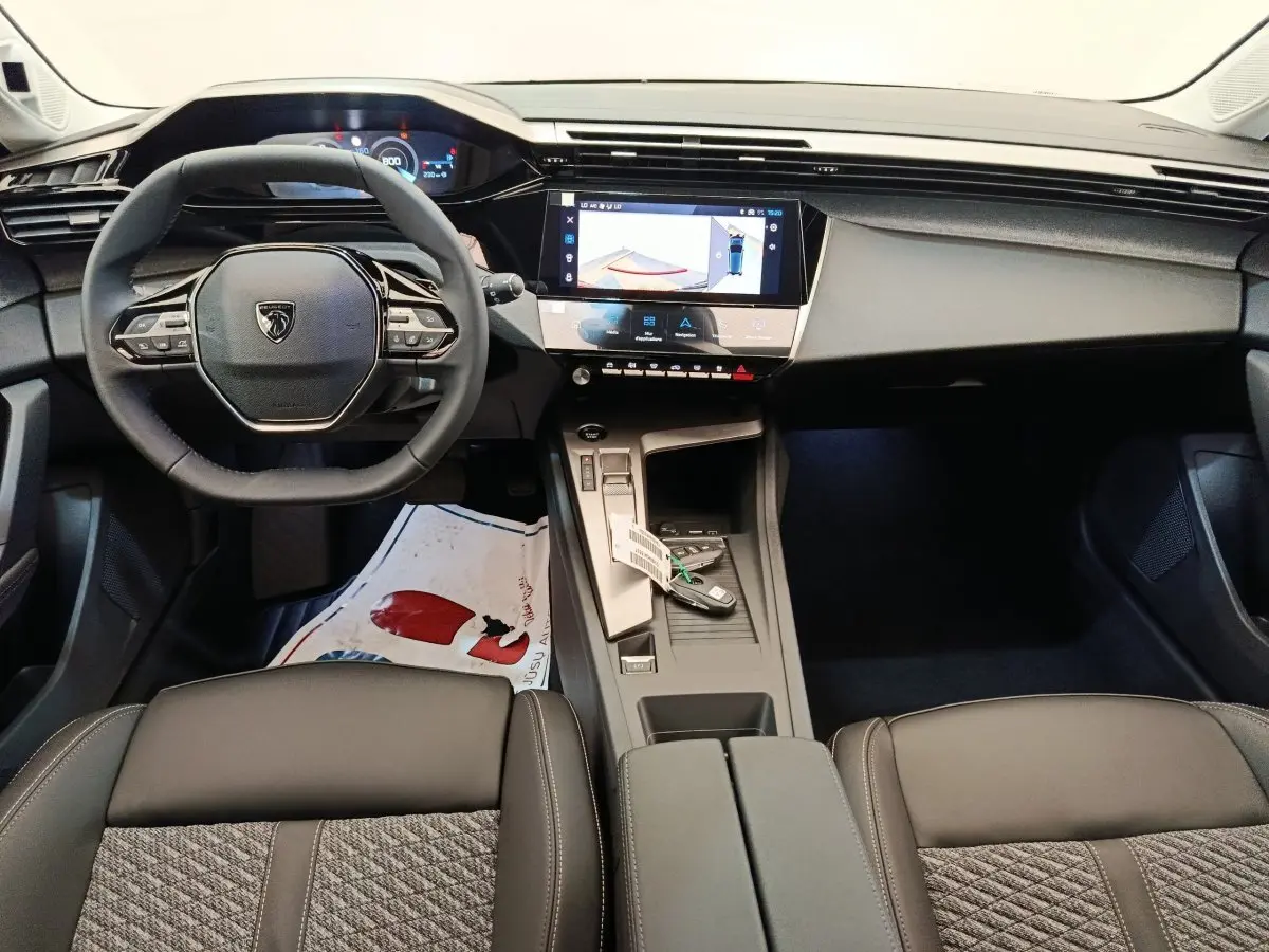 Intérieur Peugeot 308 BlueHDi 130 2026 vu de face, volant cuir multifonctions et écran tactile central allumé.
