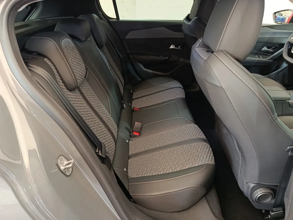 Vue intérieure côté gauche sur la banquette arrière gris foncé avec sellerie mixte tissu et cuir du Peugeot 308 2026.