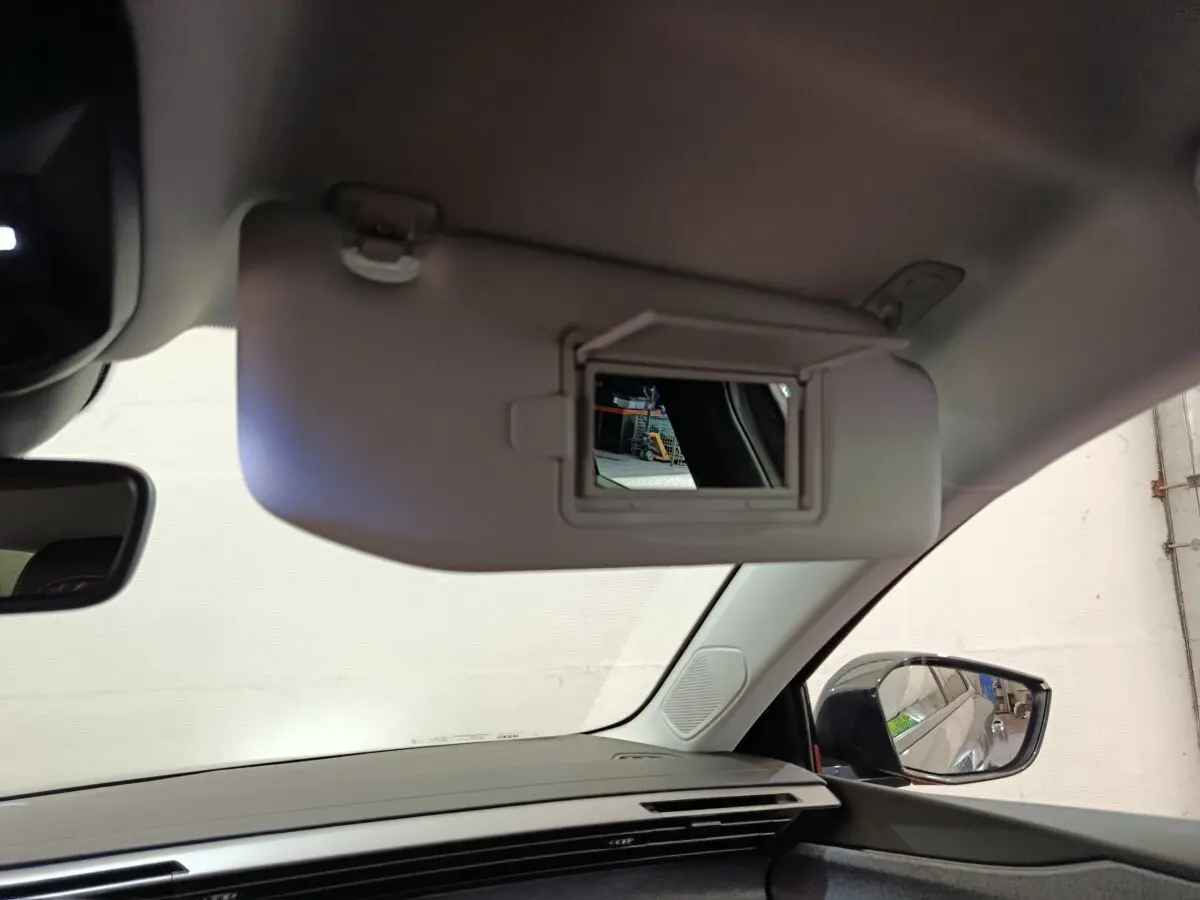 Intérieur Peugeot 308 2026, vue côté passager avec pare-soleil gris ouvert et miroir de courtoisie visible.