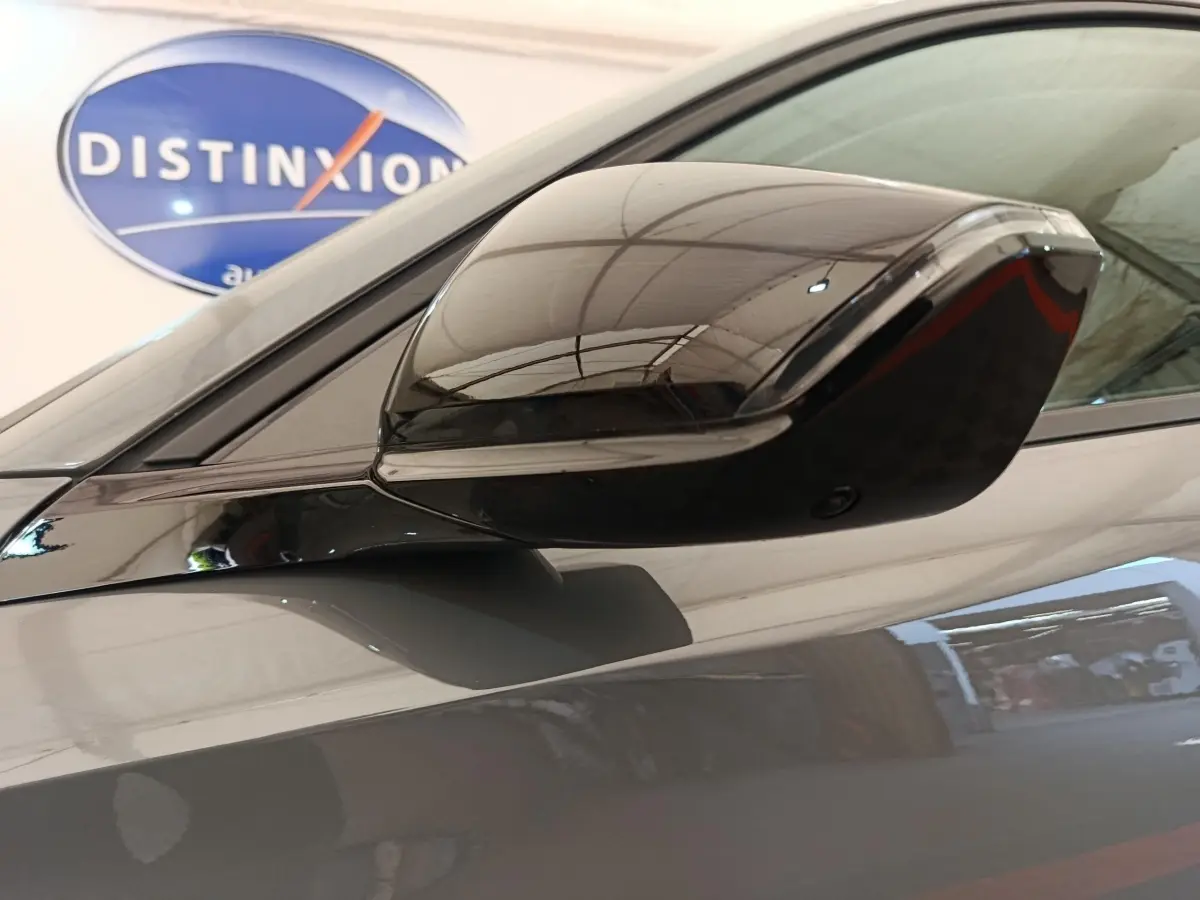 Rétroviseur droit gris foncé brillant de Peugeot 308 2026, reflet de l'intérieur du garage visible en arrière-plan.