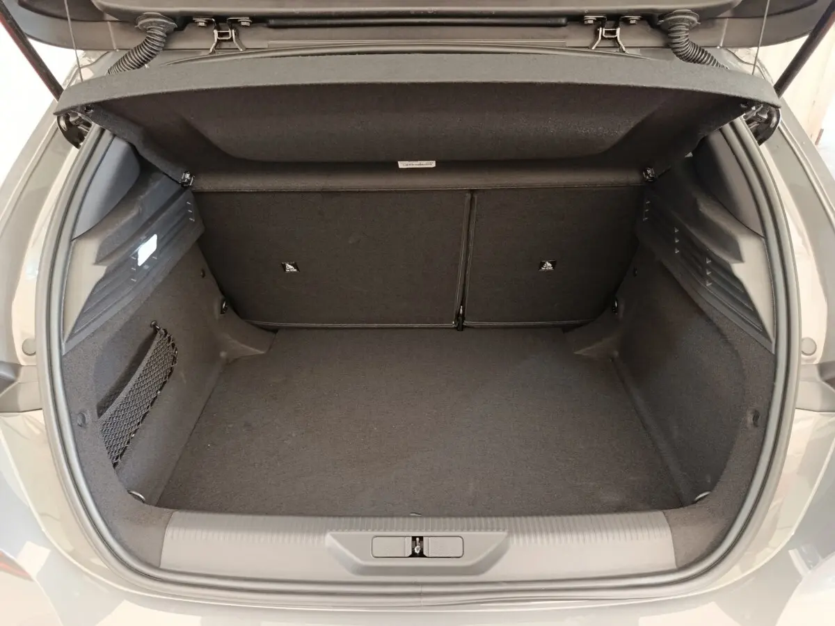 Coffre ouvert vu de l'arrière d'une Peugeot 308 gris foncé, montrant un espace de chargement propre et spacieux.