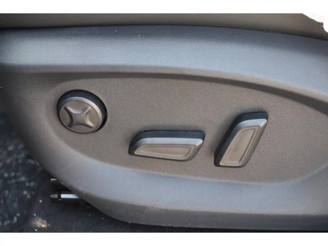 Gros plan sur les commandes électriques de réglage du siège conducteur du MG MOTOR EHS 1.5 Hybrid+ noir.
