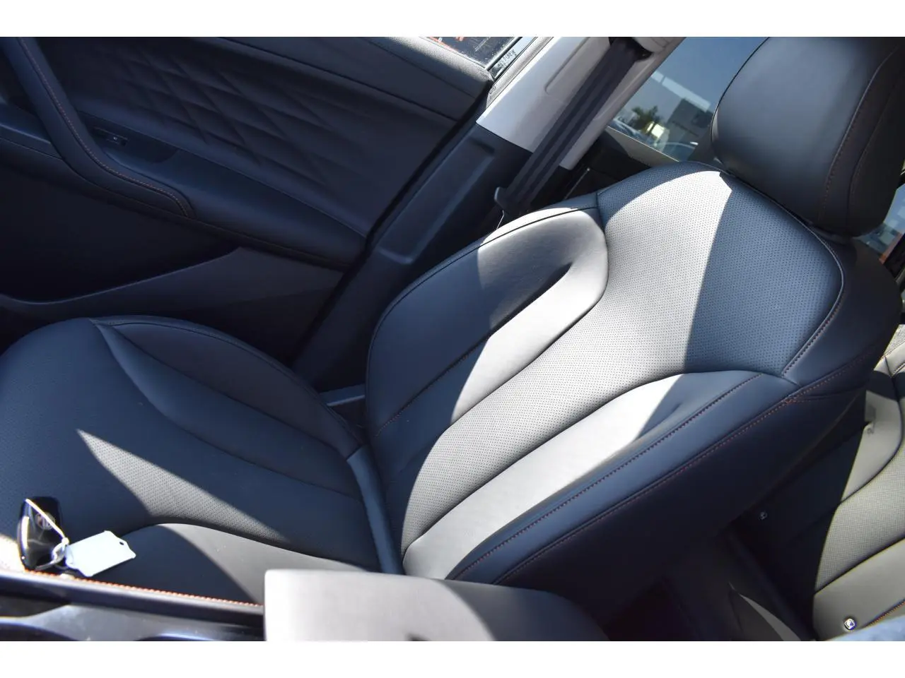 Siège avant conducteur en similicuir noir avec surpiqûres marron dans un MG MOTOR EHS 1.5 Hybrid+ Luxury 2026.