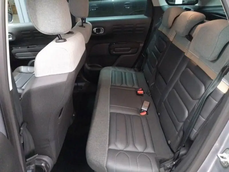 Vue intérieure arrière droite du Citroën C3 Aircross 2022 gris, sièges mixtes cuir et tissu avec appuie-têtes réglables.