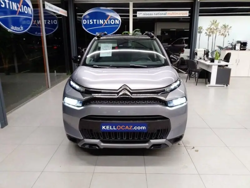 Vue frontale d'un Citroën C3 Aircross gris 2022 avec feux LED allumés, exposé en showroom Distinxion.